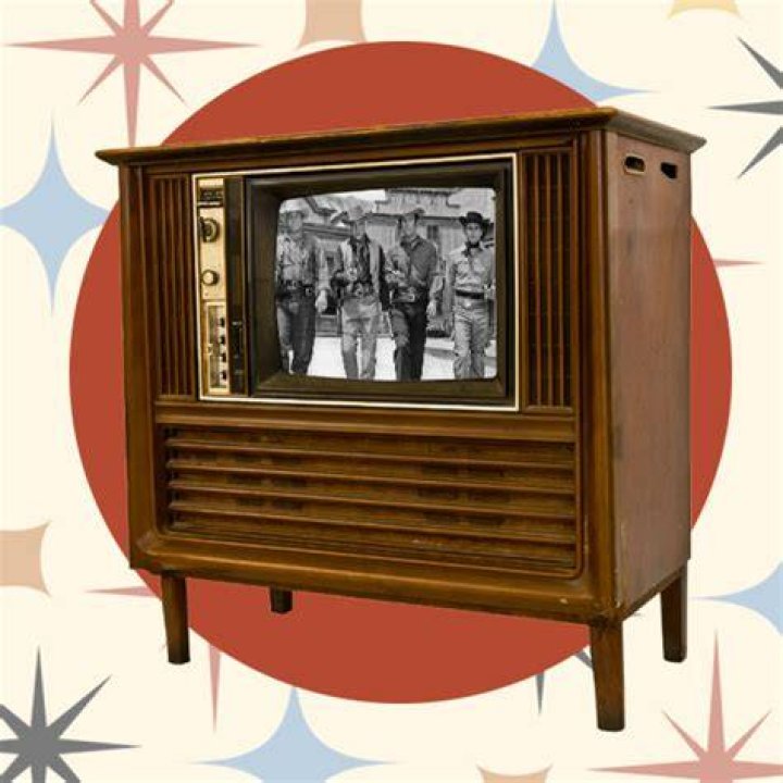 an old tv with two people kissing on the screen and microphones in
